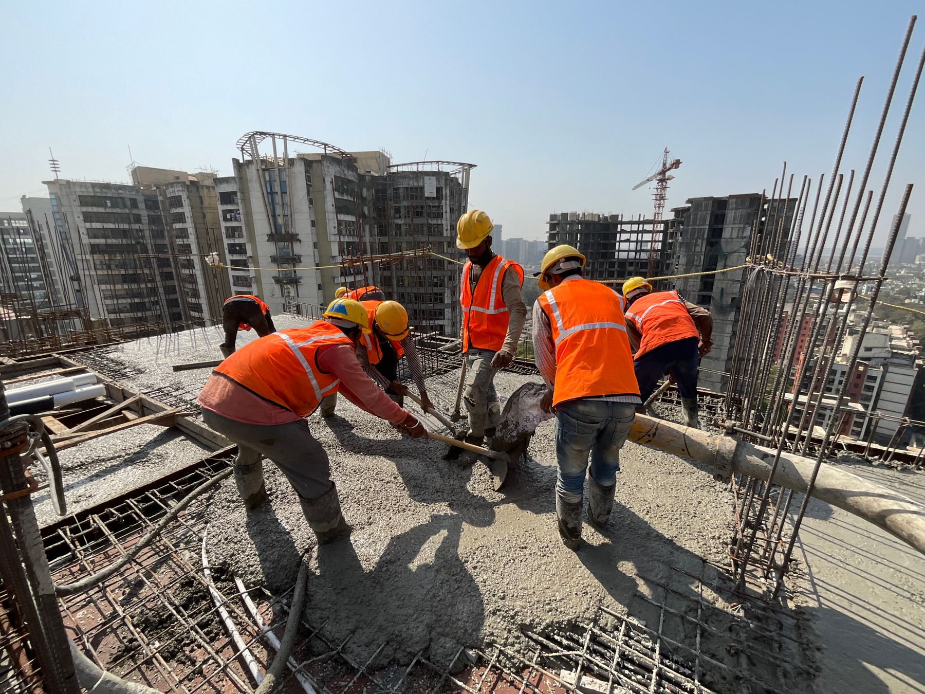 Concrete crew placing and screeding a freshly poured slab on a jobsite